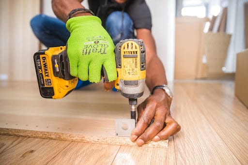 Contractor using cordless drill on wood during renovation